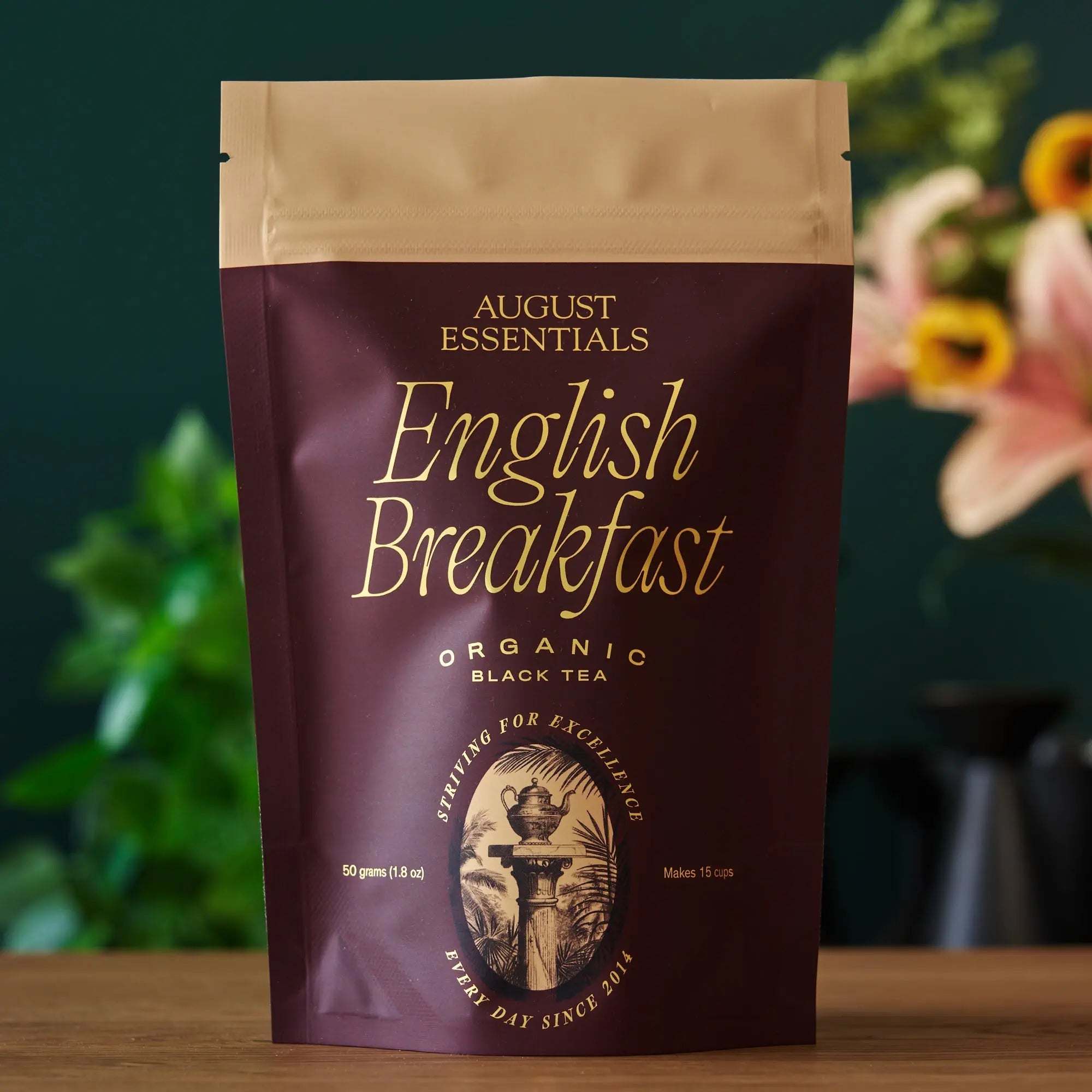 Essentials English Breakfast Black Tea in a burgundy and tan resealable pouch, organic black tea packaging with gold lettering
