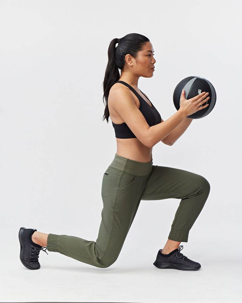 Excel Jogger in olive green stretch fabric with a slim fit, side pockets and cropped elastic cuffs, worn for exercise