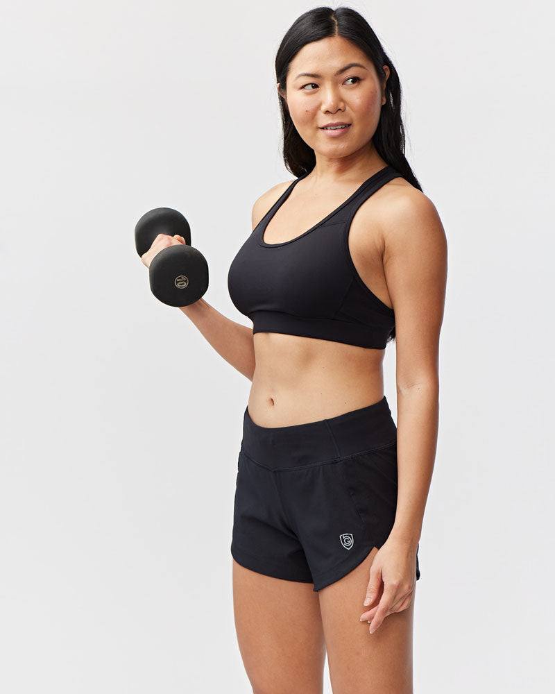 Excel Women's Workout Shorts in black stretch fabric, featuring a wide waistband and curved overlapping hem
