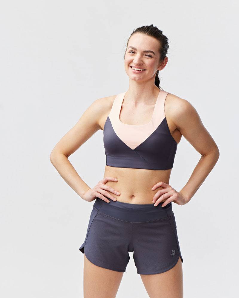 Excel Women's Workout Shorts in charcoal gray stretch fabric, with a wide waistband, curved hems, and side slits
