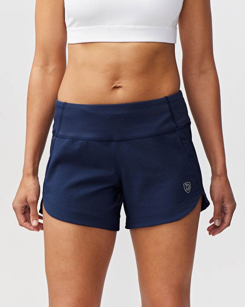 Excel Women's Workout Shorts in navy stretch fabric, featuring a wide crossover waistband, curved hems and a small logo