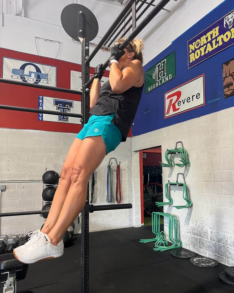 Excel Women's Workout Shorts in bright turquoise with a smooth stretch fabric, worn during a pull-up workout
