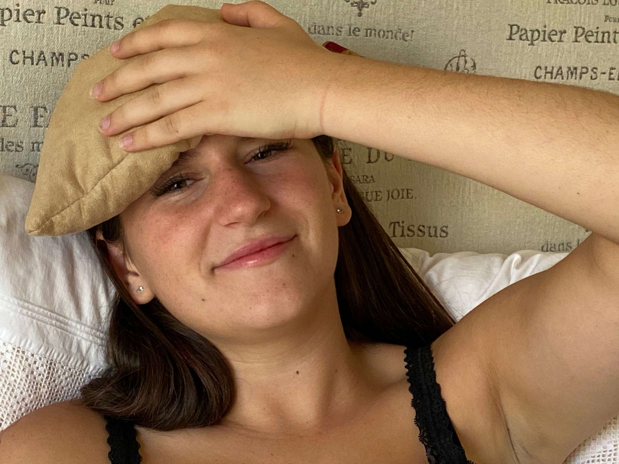 Eye Pillow in Tan, soft suede-like fabric with a plain surface, resting across a woman's forehead