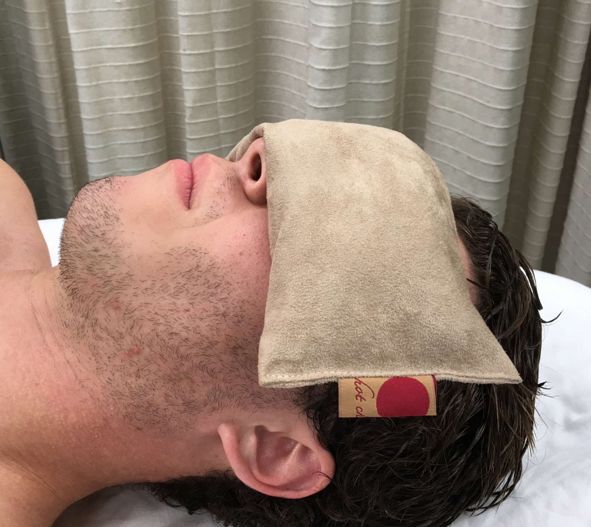 Eye Pillow in Tan, soft suede-like fabric with a smooth solid finish, resting over a person's eyes