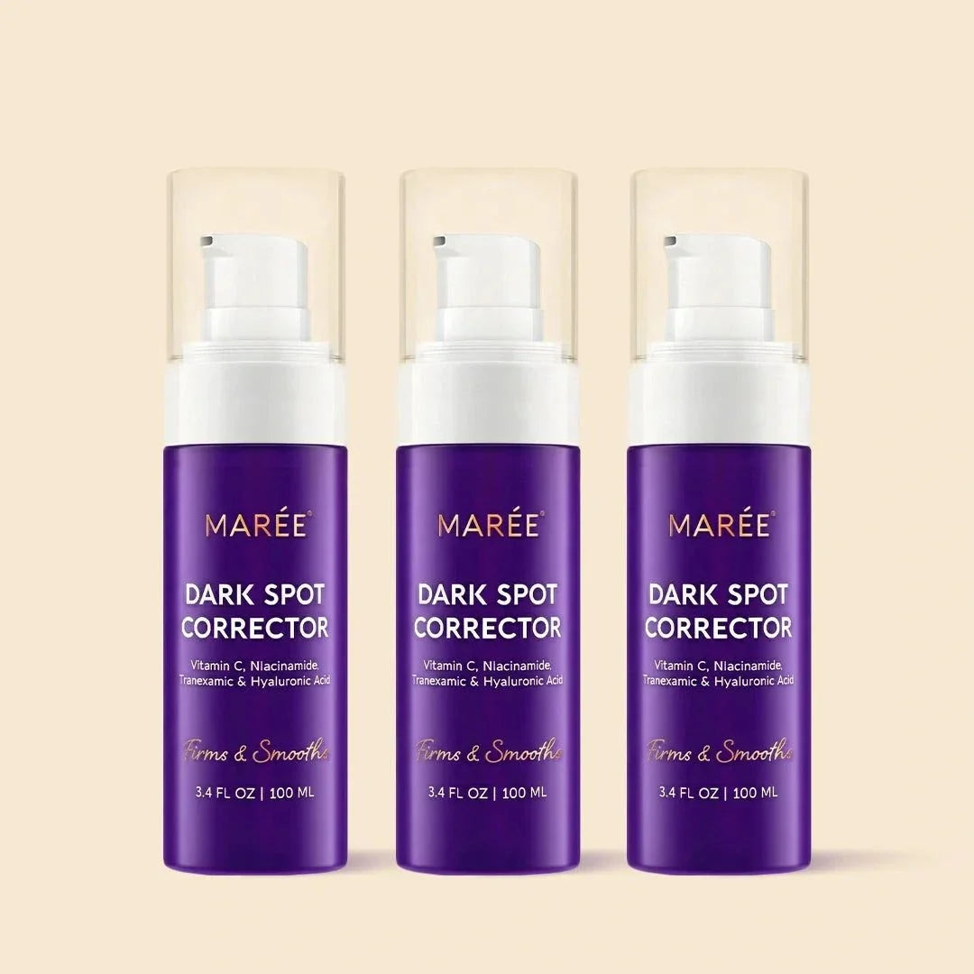 Face & Body Serum in three purple Marée Dark Spot Corrector bottles with white pump tops and clear caps