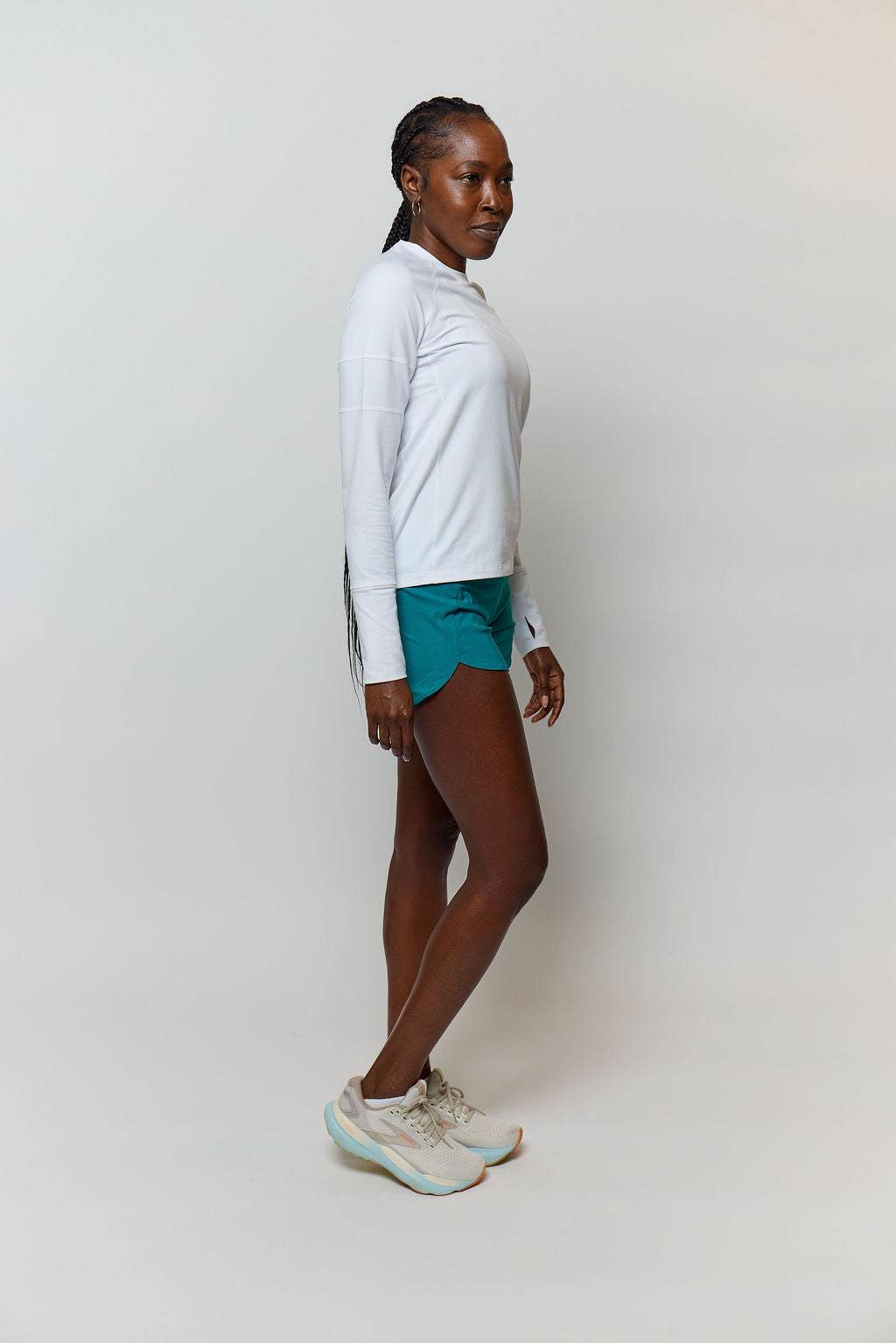 Foudy 2.0 Women's long-sleeve athletic top in white, with a crew neck and relaxed fit, worn with teal shorts