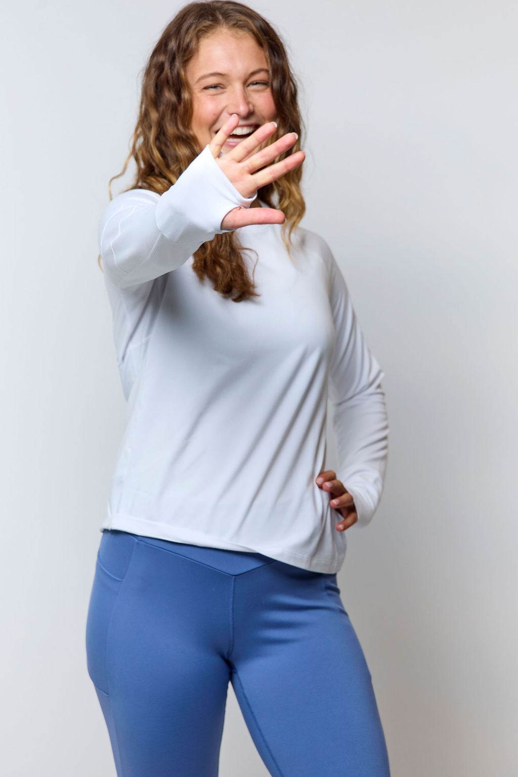 Foudy 2.0 Women's long sleeve athletic top in white, with a smooth fabric, crew neckline and thumb-loop cuffs