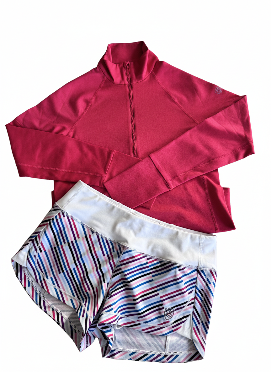 Foudy Mid-Weight Long Sleeve in raspberry red with a high collar and half zip, paired with striped athletic shorts