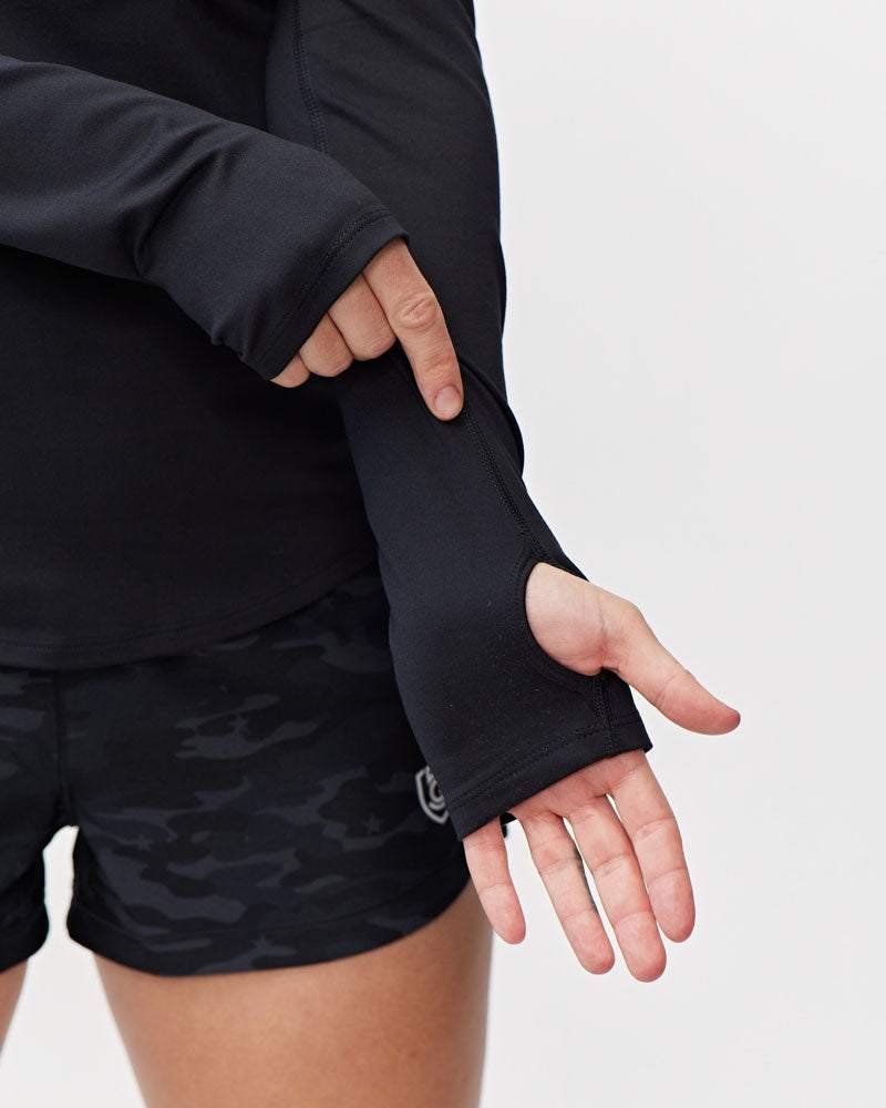 Foudy Women's Longsleeve workout top in black soft fabric, featuring long sleeves with thumbhole cuffs and a fitted cut