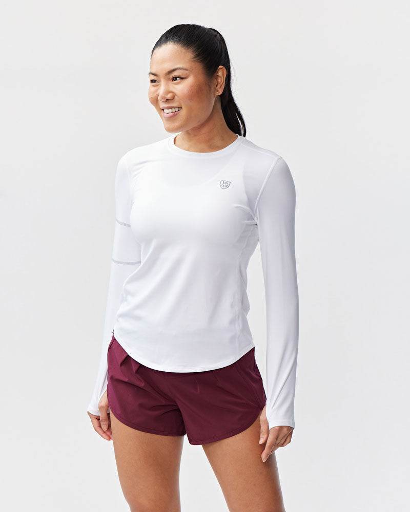 Foudy Women's Longsleeve white workout top in soft fabric, with long sleeves, subtle chest logo and curved hem