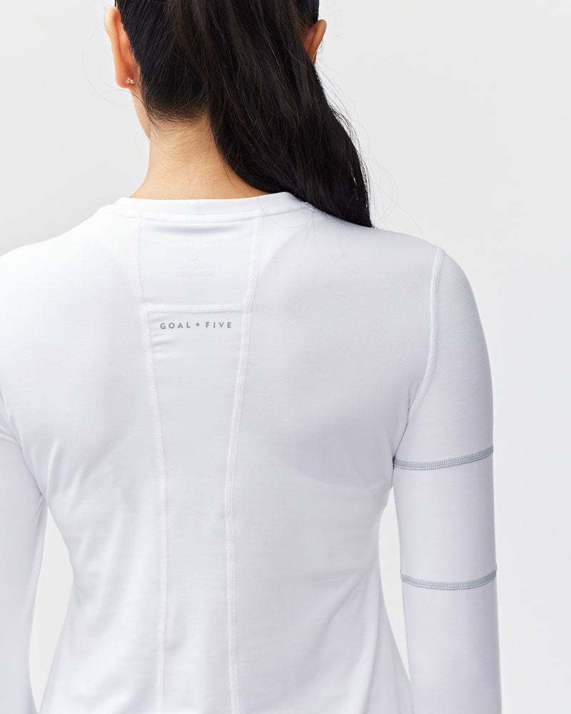 Foudy Women's Longsleeve workout top in white, with long sleeves, a fitted shape, and subtle gray seam details