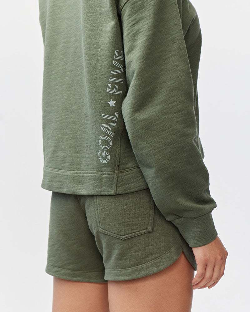 Freasy Crew sweatshirt in muted olive green with a soft, garment-dyed finish and vertical GOAL FIVE lettering