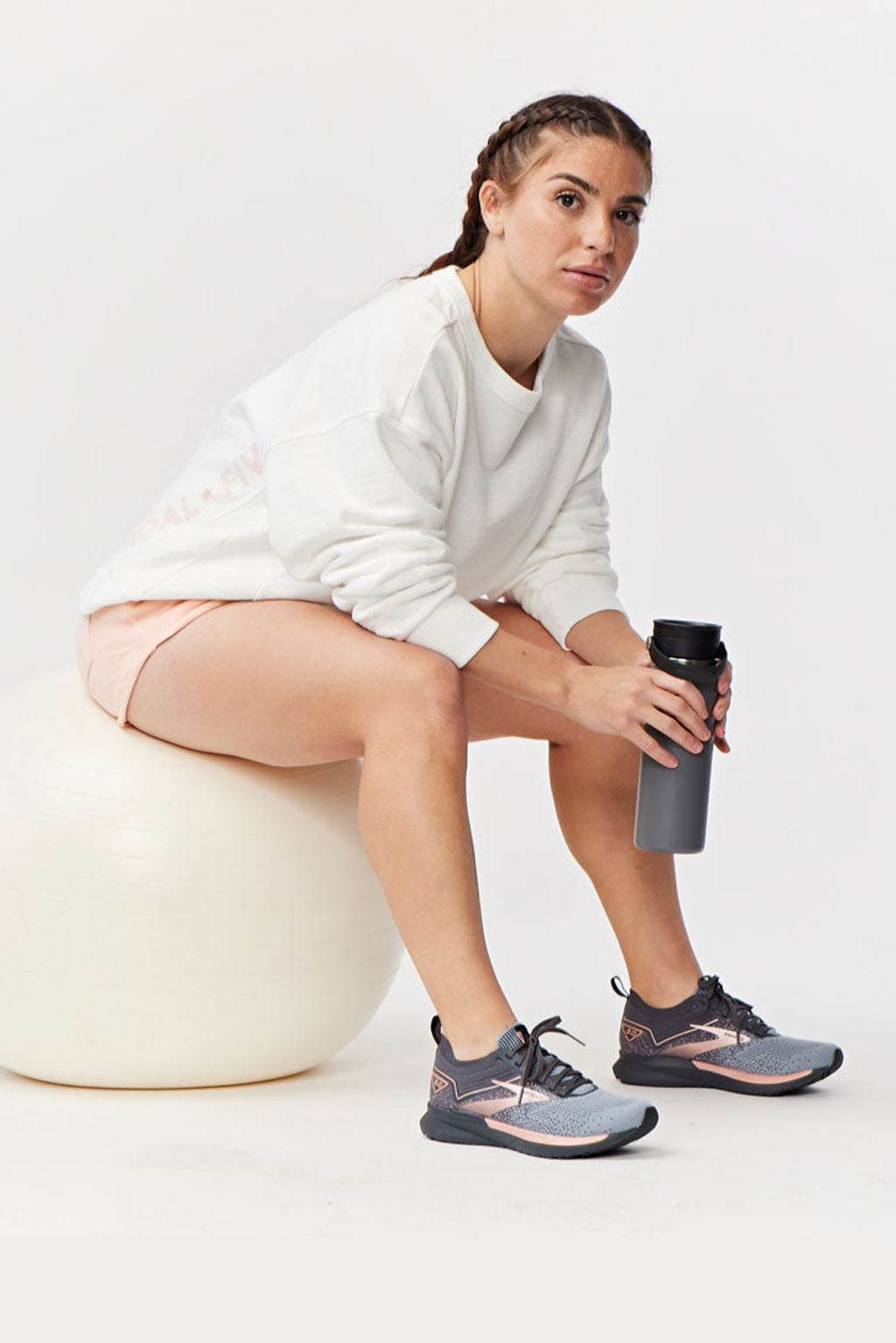 Freasy Crew sweatshirt in white with a soft, plain finish and relaxed fit, worn with peach shorts