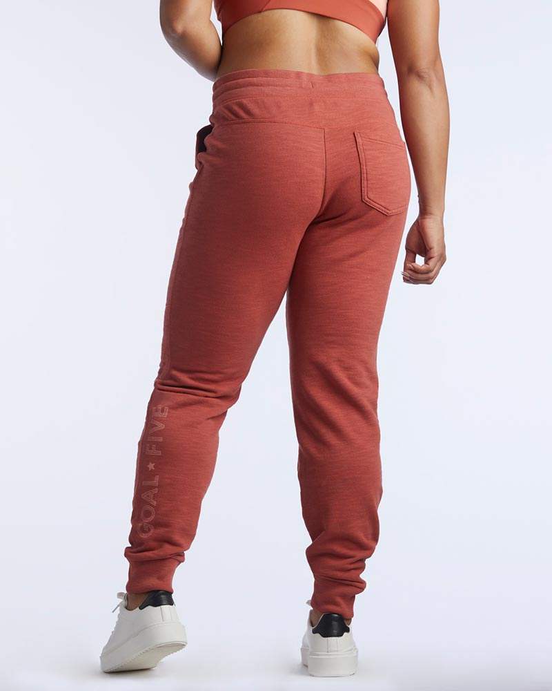 Freasy Jogger in rust red with a soft knit finish, tapered legs, ribbed ankle cuffs and a back pocket