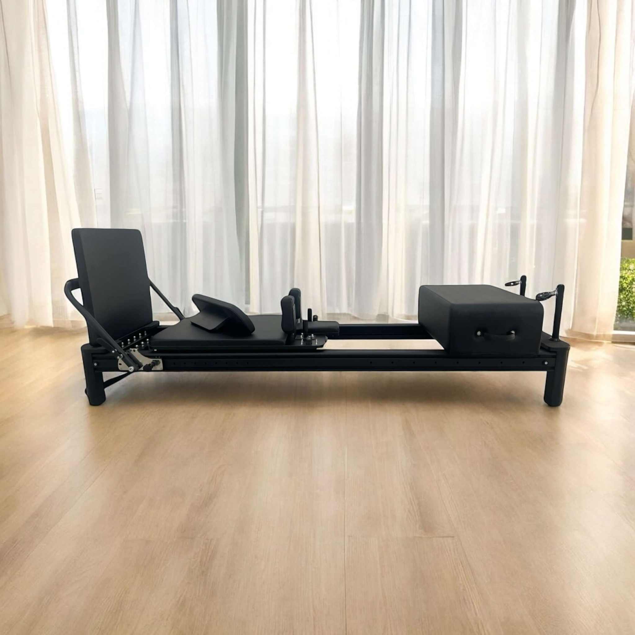 Full Track Queen Studio Pilates reformer with full-track footbar and black upholstery