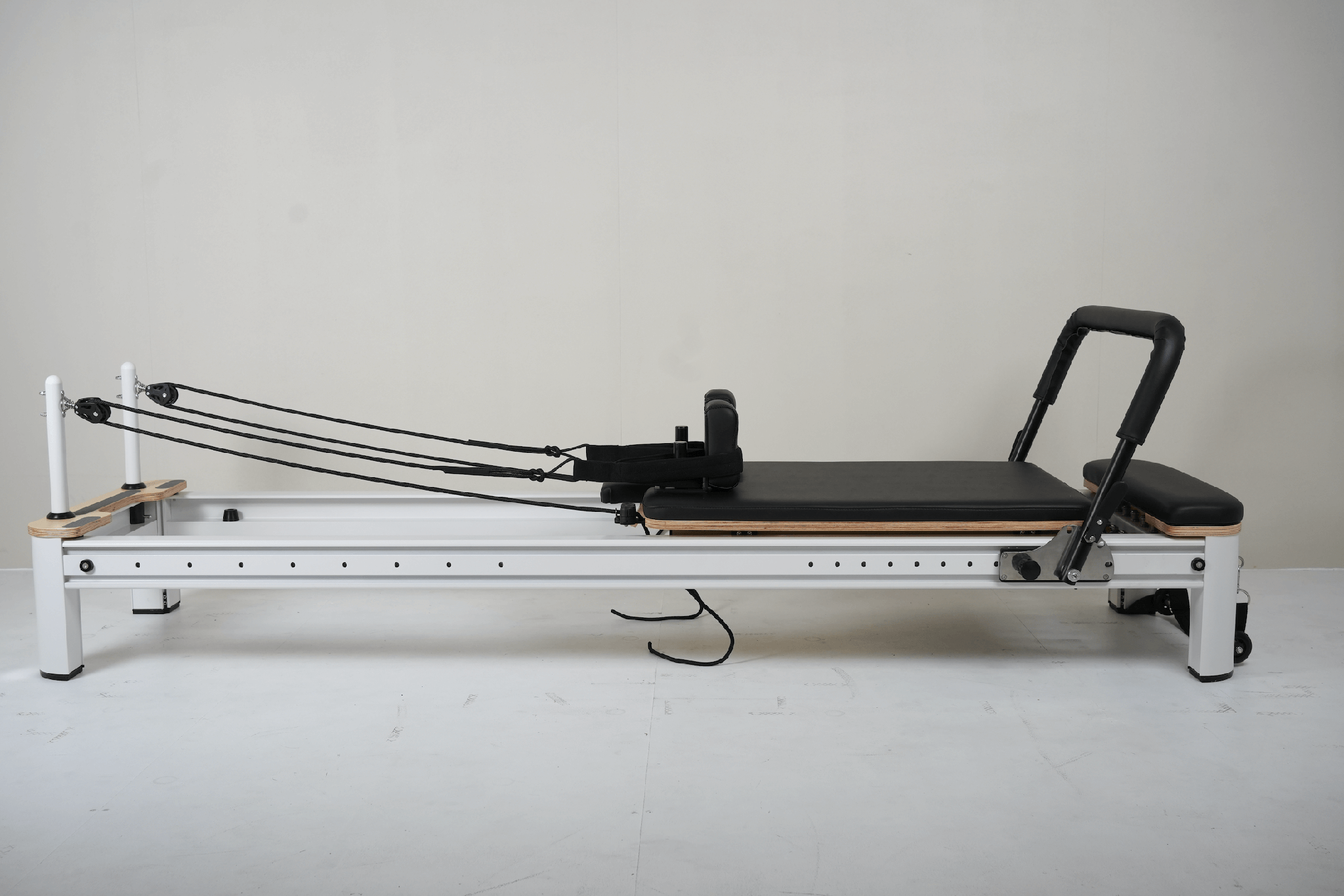 Full Track Queen Studio Pilates Reformer with black frame and upholstery