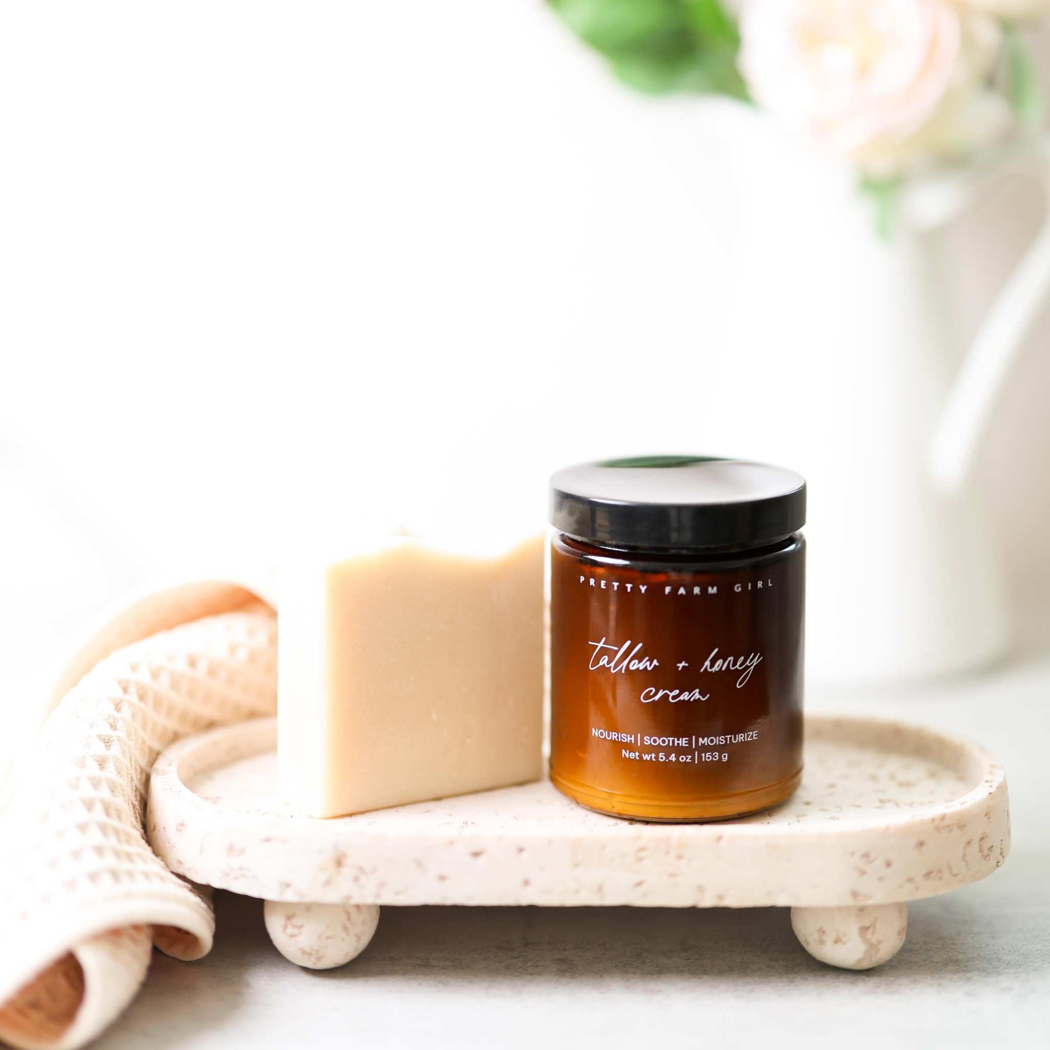 Gentle Care Duo for Mom + Baby with amber tallow and honey cream jar beside a creamy beige soap bar
