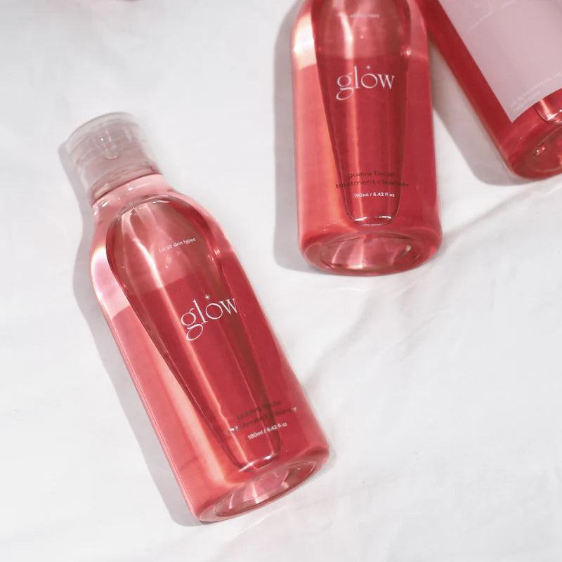 Glow Guava Facial Cleanser in transparent pink plastic bottles with white caps, featuring a sleek modern design.