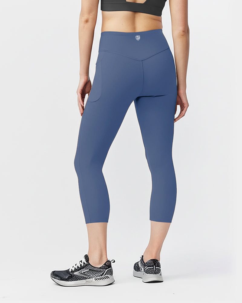 Go Again Crop Legging in solid blue stretch fabric, with a high-rise waistband, cropped length and side pockets