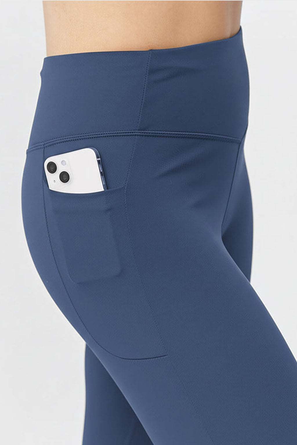 Go Again Crop Legging in solid navy stretch fabric, featuring a high-rise waistband and a side pocket holding a phone.