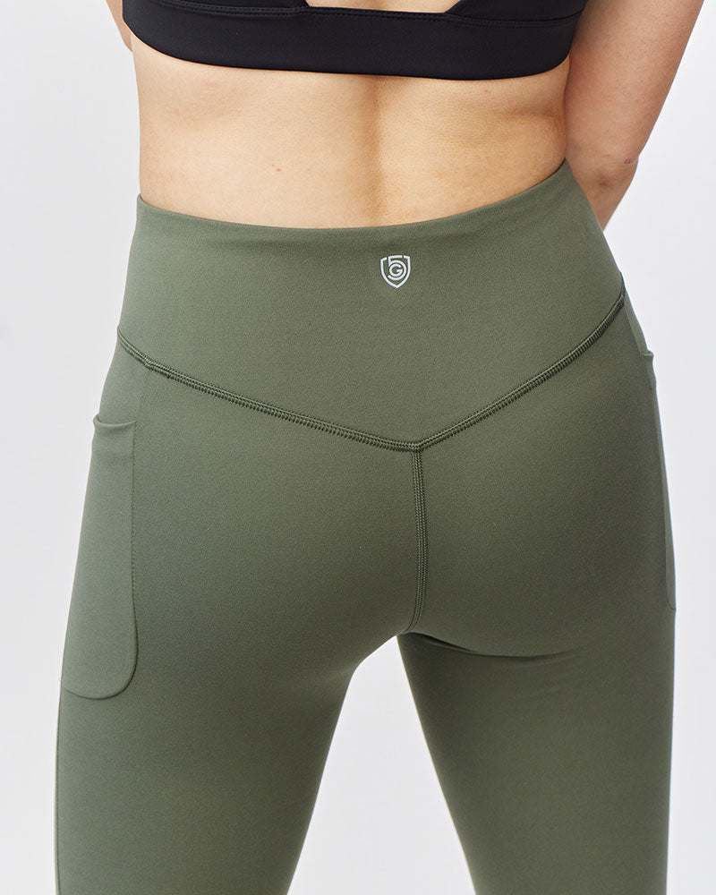 Go Again Crop Legging in olive green stretch fabric with a high-rise V-shaped waistband and side pockets