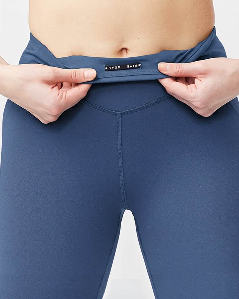 Go Again Crop Legging in solid slate blue stretch fabric, featuring a high-rise waistband and small black logo tag