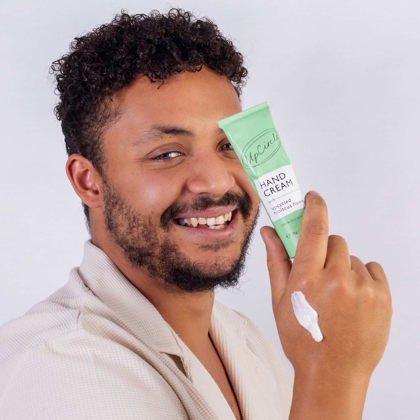 Hand Cream with Hibiscus Flowers in a mint green tube, shown with white cream applied to a hand