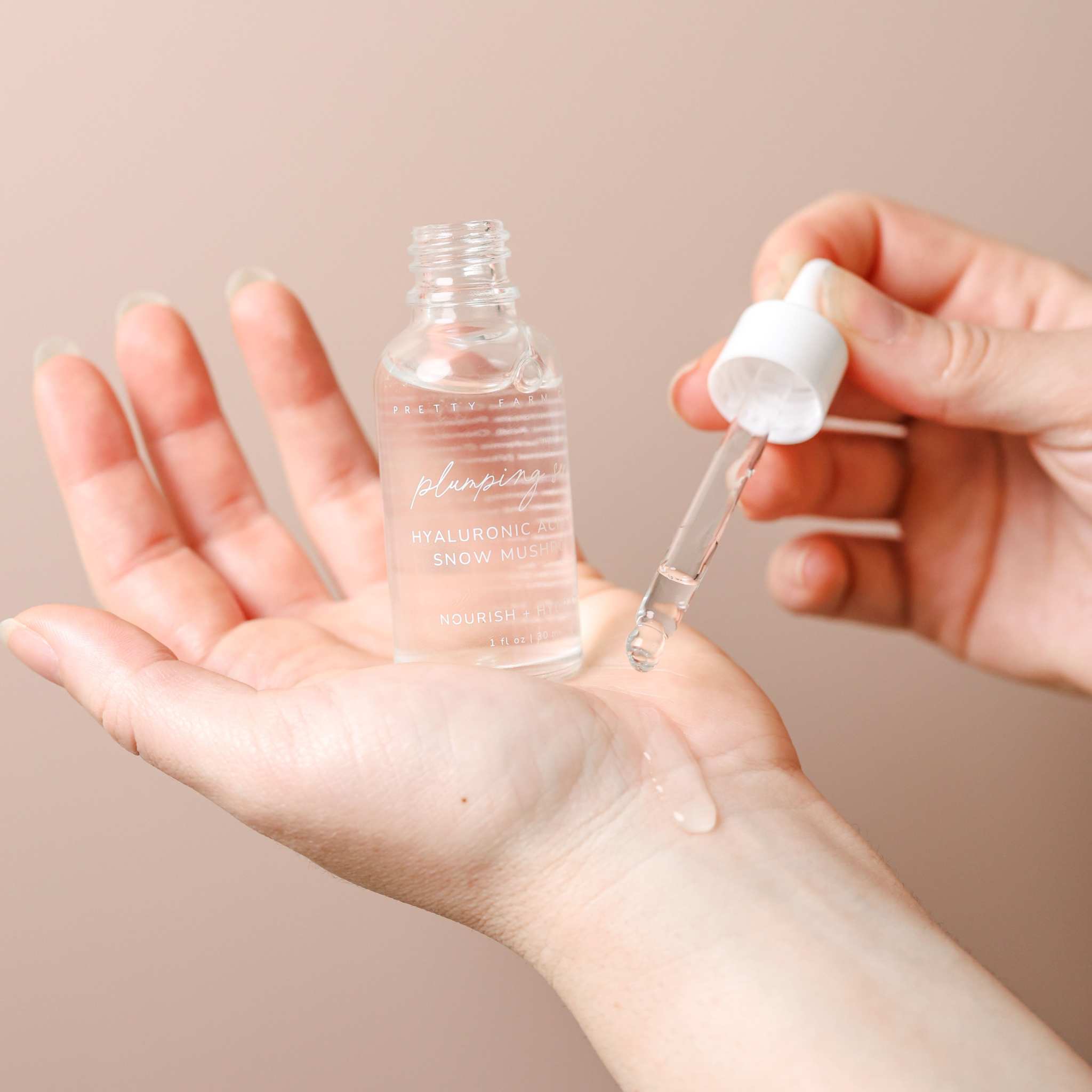 Hyaluronic Acid Plumping Serum in a clear glass dropper bottle, with clear serum on hand and Vitamin B5 formula label