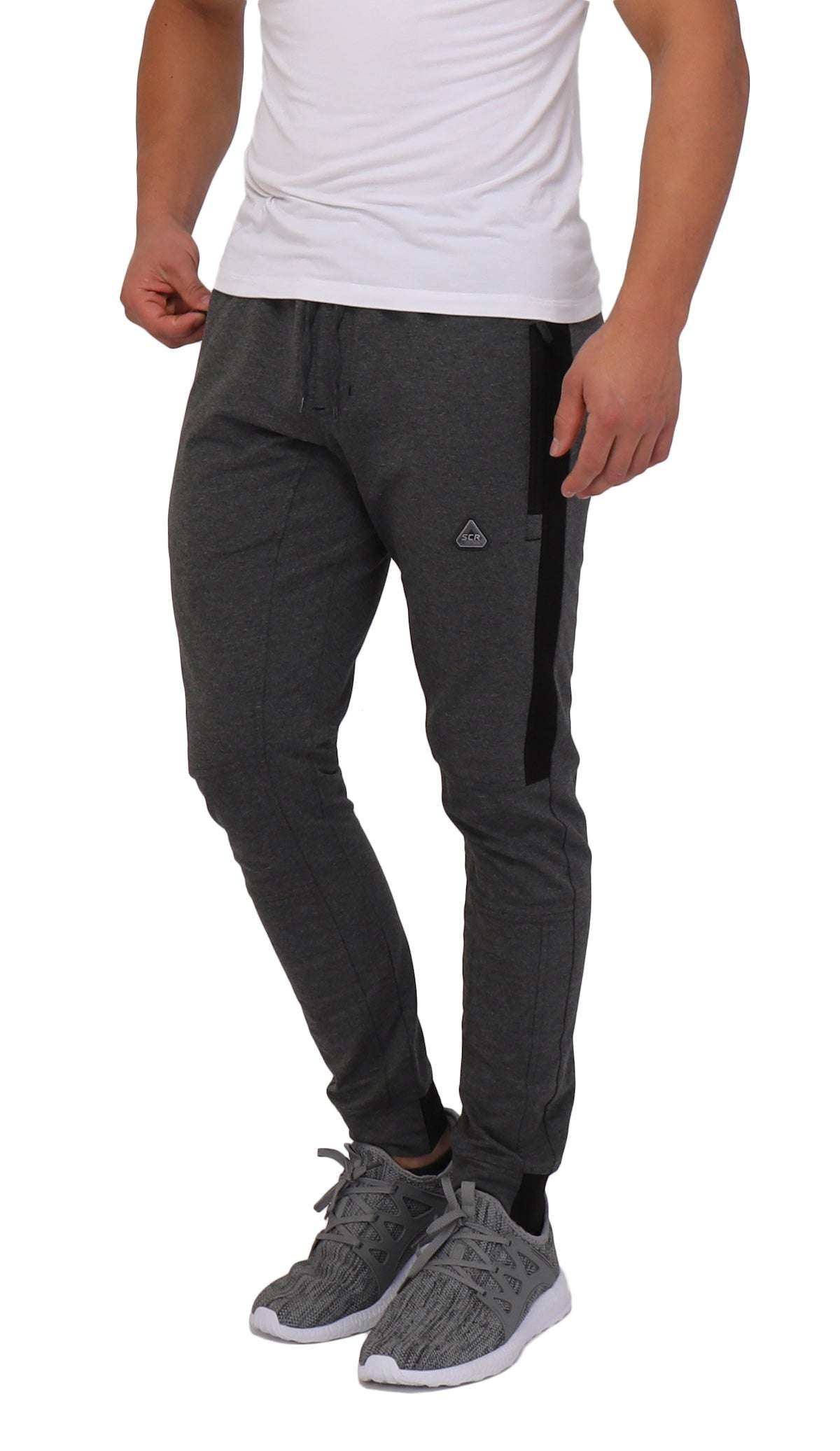 Infinite Flex Jogger in charcoal gray stretch fabric with black side panels, tapered legs, cuffed ankles, and a small logo
