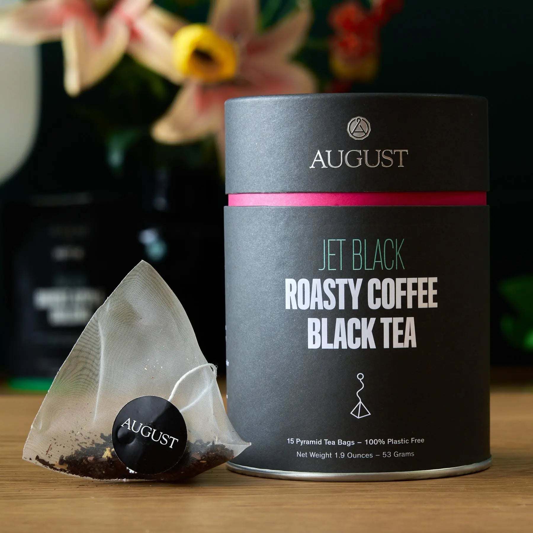 Jet Black - Roasty Coffee Black Tea - 15 Bags in a matte black tin with pink band and pyramid tea bag beside it