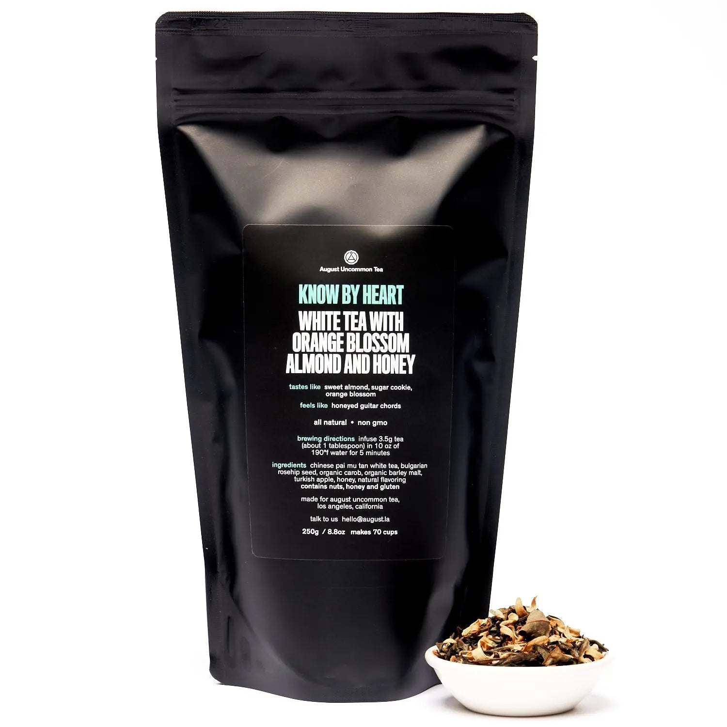 Know by Heart white tea in a matte black resealable pouch with orange blossom, almond and honey, beside loose tea