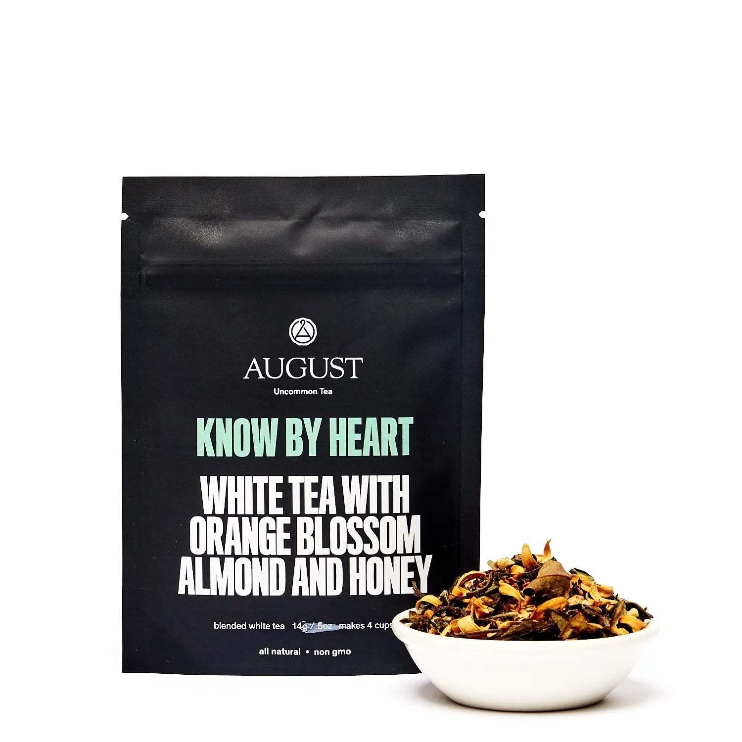 Know by Heart white tea with orange blossom, almond and honey in a black pouch beside a bowl of loose tea