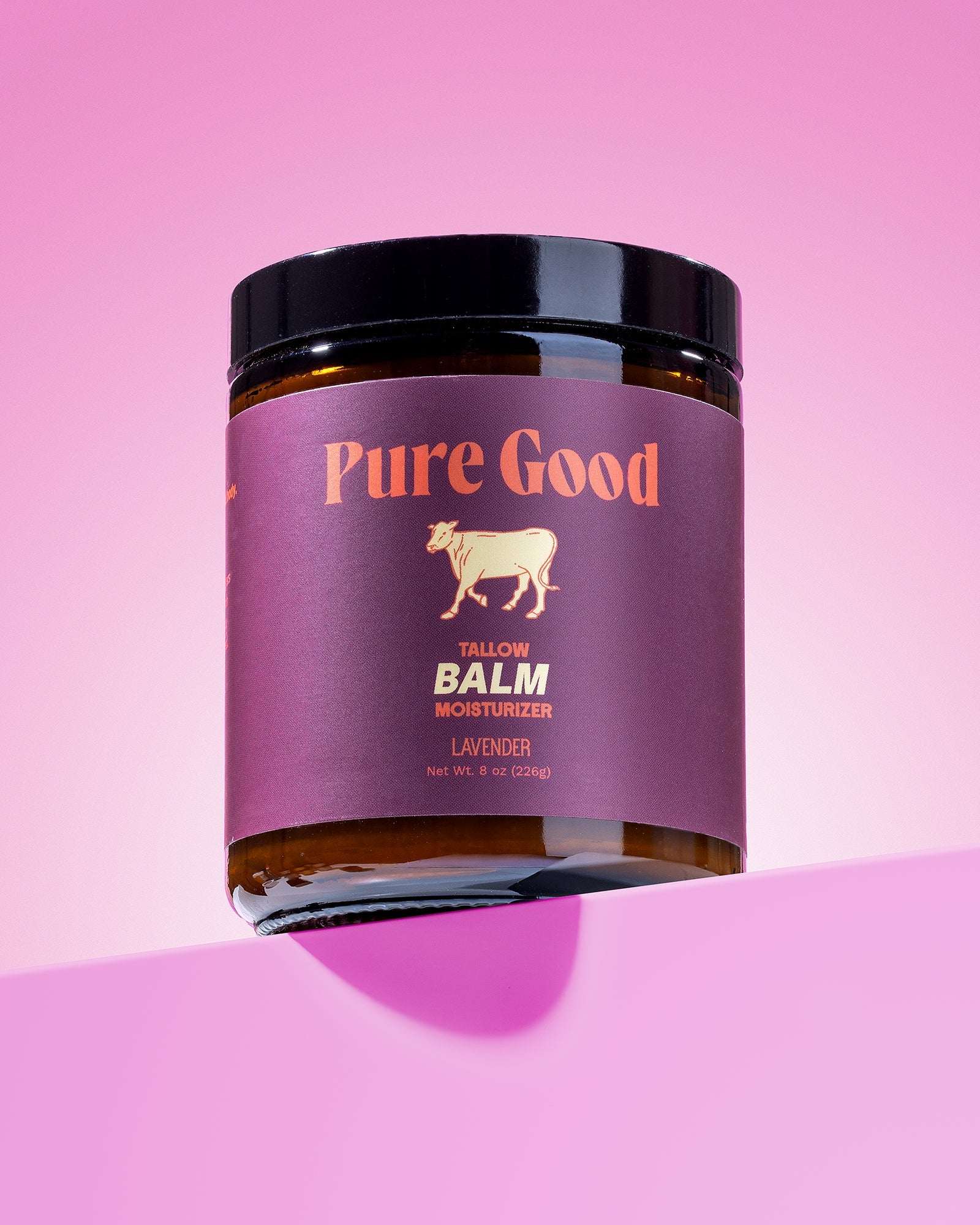 Lavender Tallow Balm in a dark amber jar with a black lid, purple label, and Pure Good branding