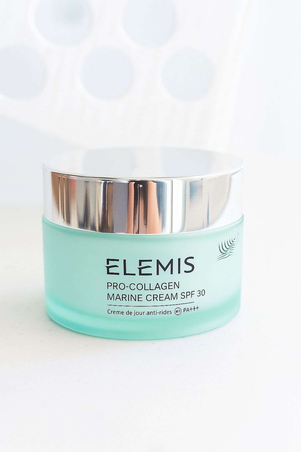 Facial moisturizer jar in aqua and silver with ELEMIS Pro-Collagen Marine Cream SPF 30 label; Lightweight anti-wrinkle daily facial moisturizer