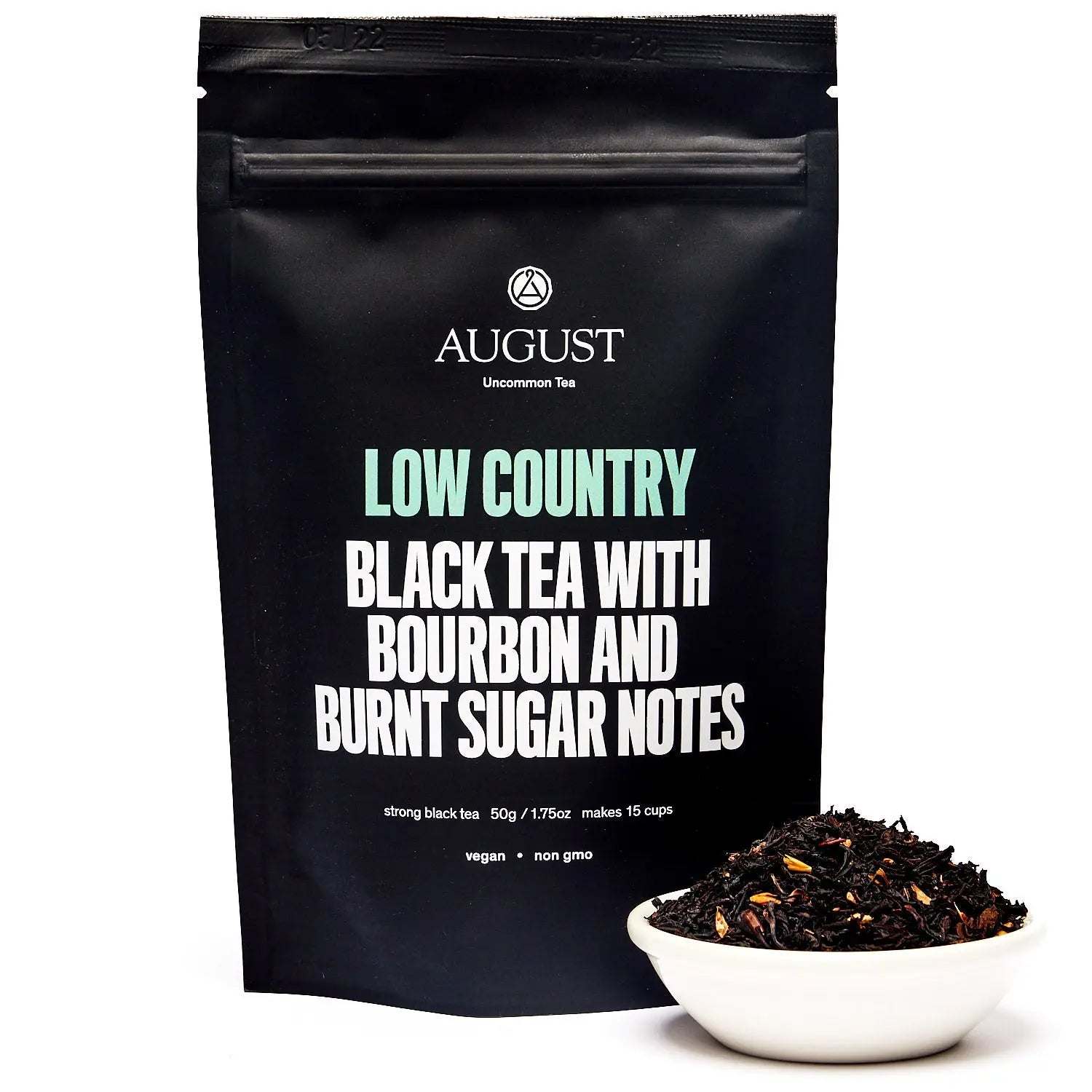 Low Country Black Tea in a matte black pouch, with loose dark tea leaves in a white bowl beside it