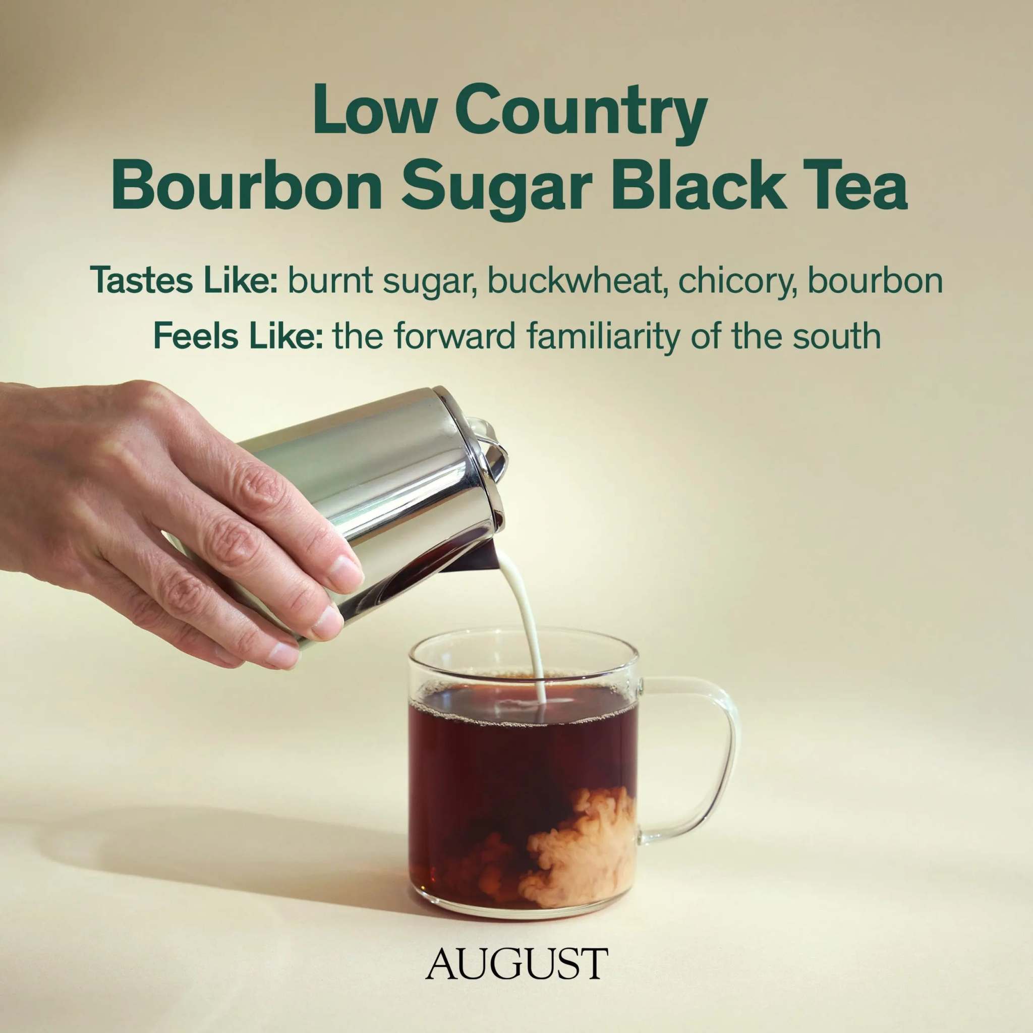 Low Country Black Tea, rich dark amber brew with cream swirling in a clear glass mug beside a chrome pourer