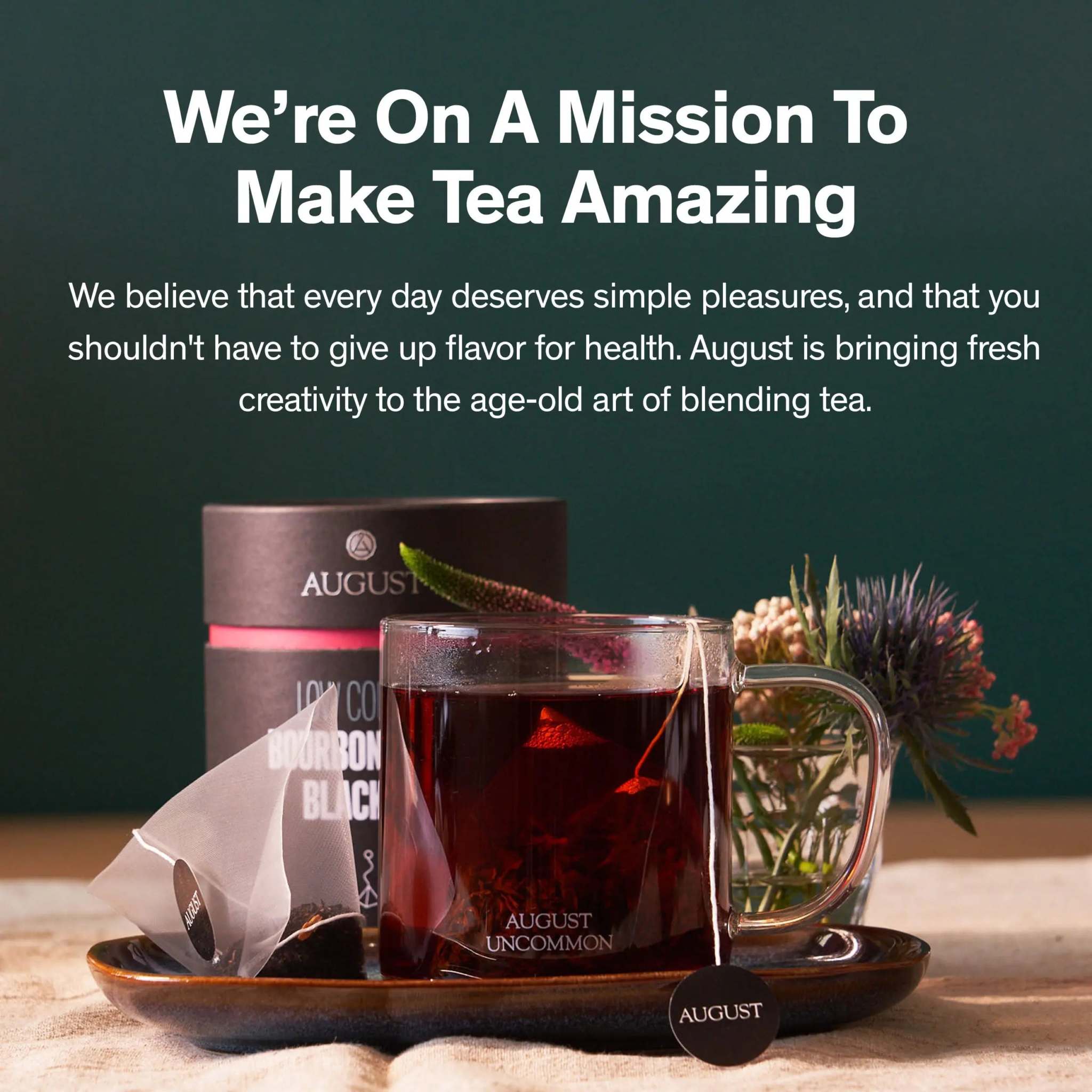 Low Country Black Tea in a black cylindrical tin with a glass cup of dark tea and tea sachet beside it