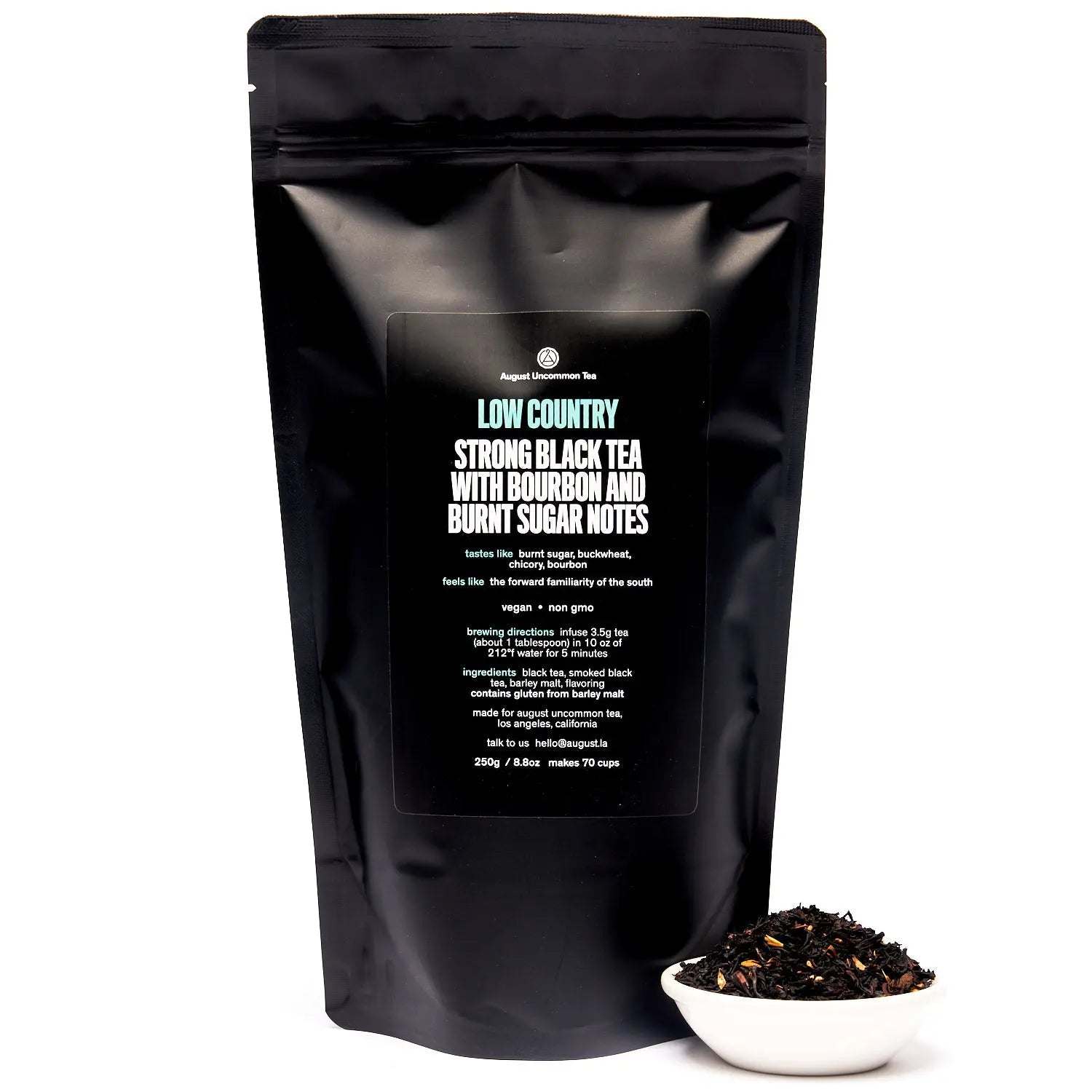 Low Country Black Tea in a matte black resealable pouch with a bowl of loose dark tea leaves and orange petals