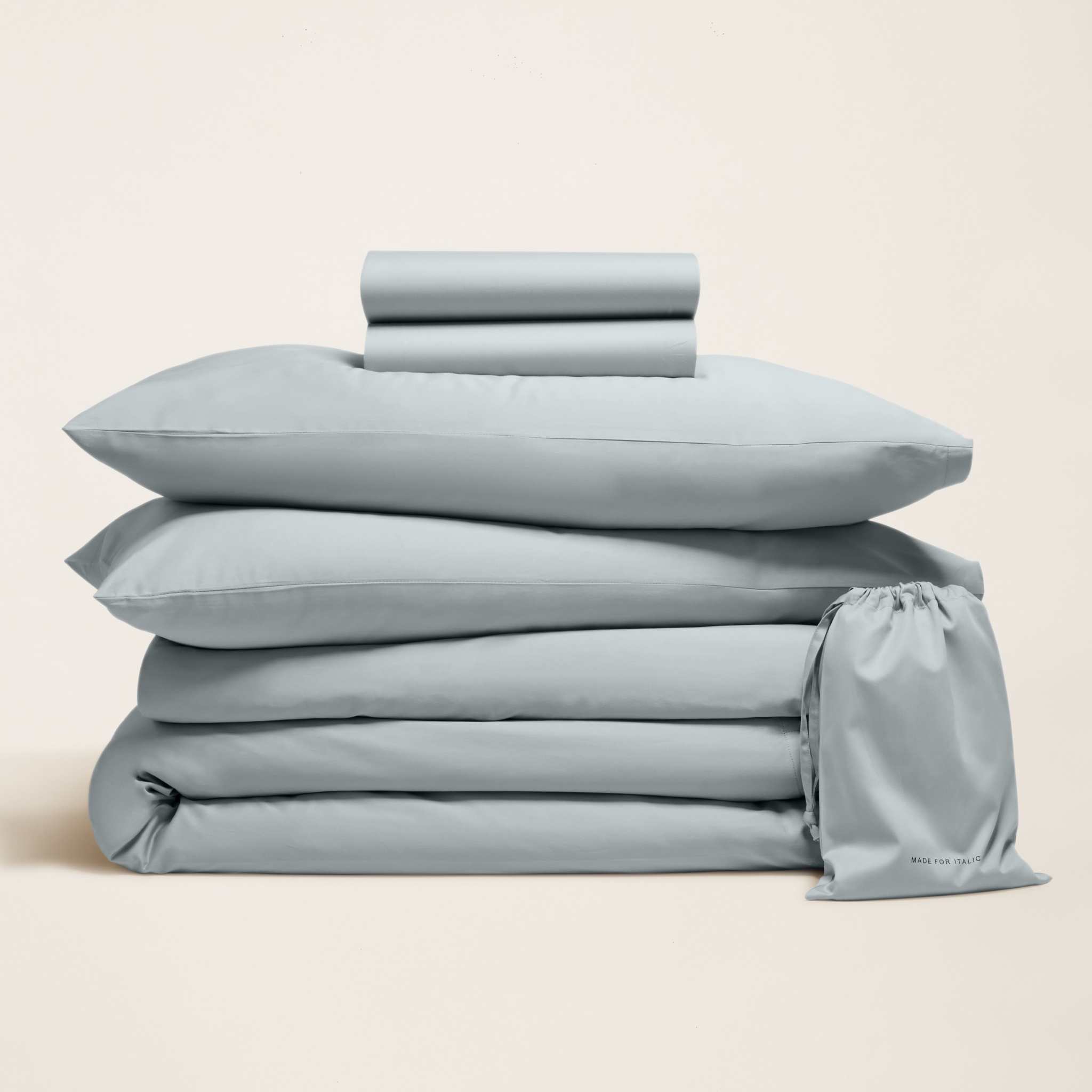 Luxe Australian Sateen Bedding bundle in pale blue, with neatly folded cotton sheets, pillowcases and a drawstring bag