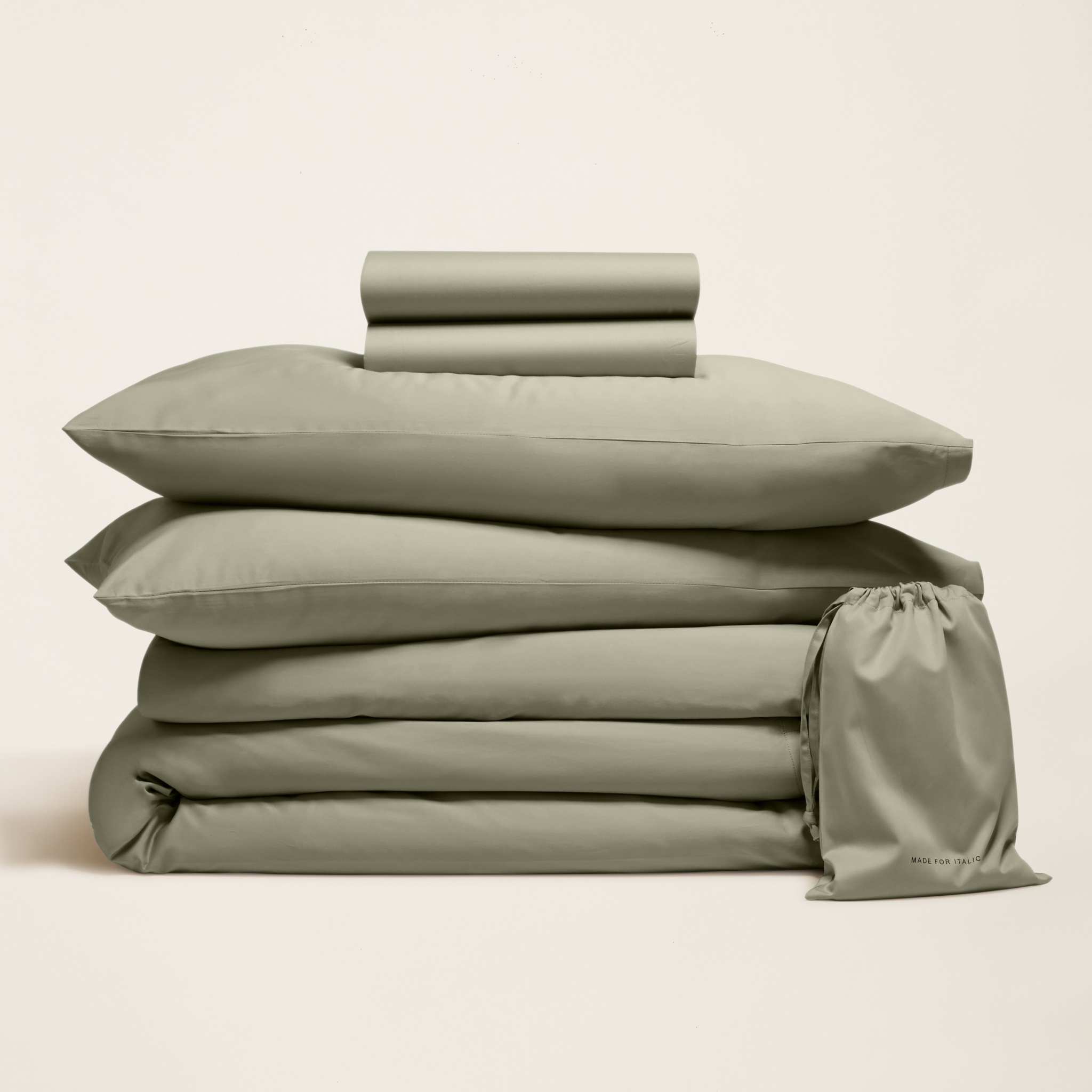 Bedding set in soft sage green sateen cotton, folded sheets and pillowcases with a matching drawstring storage bag; Luxe Australian Sateen Bedding