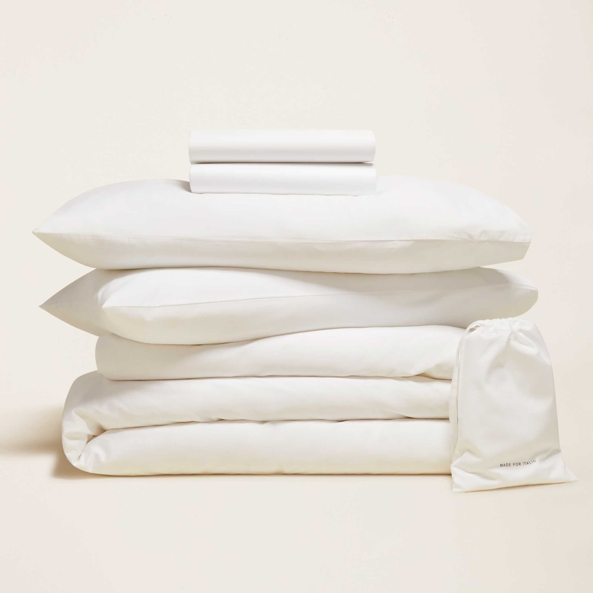 Luxe Australian Sateen Bedding bundle in white cotton sateen, neatly folded with stacked pillows and a drawstring bag