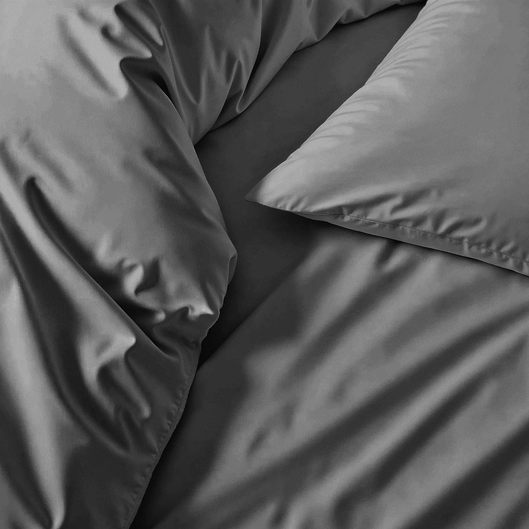Duvet cover in charcoal gray sateen cotton with a smooth, subtle sheen and matching pillowcase visible.