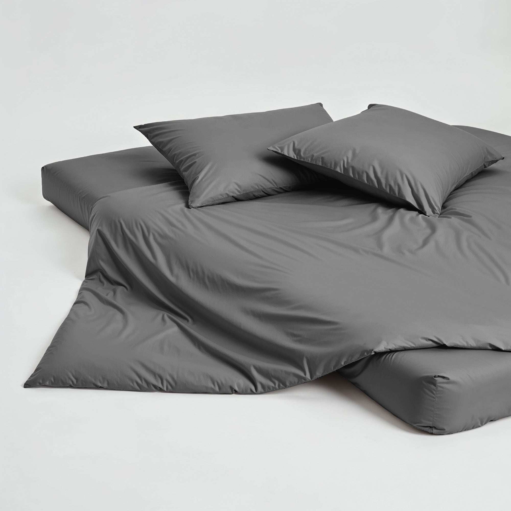 Luxe Australian Sateen duvet cover in charcoal gray with a smooth, subtly lustrous finish and matching pillowcases