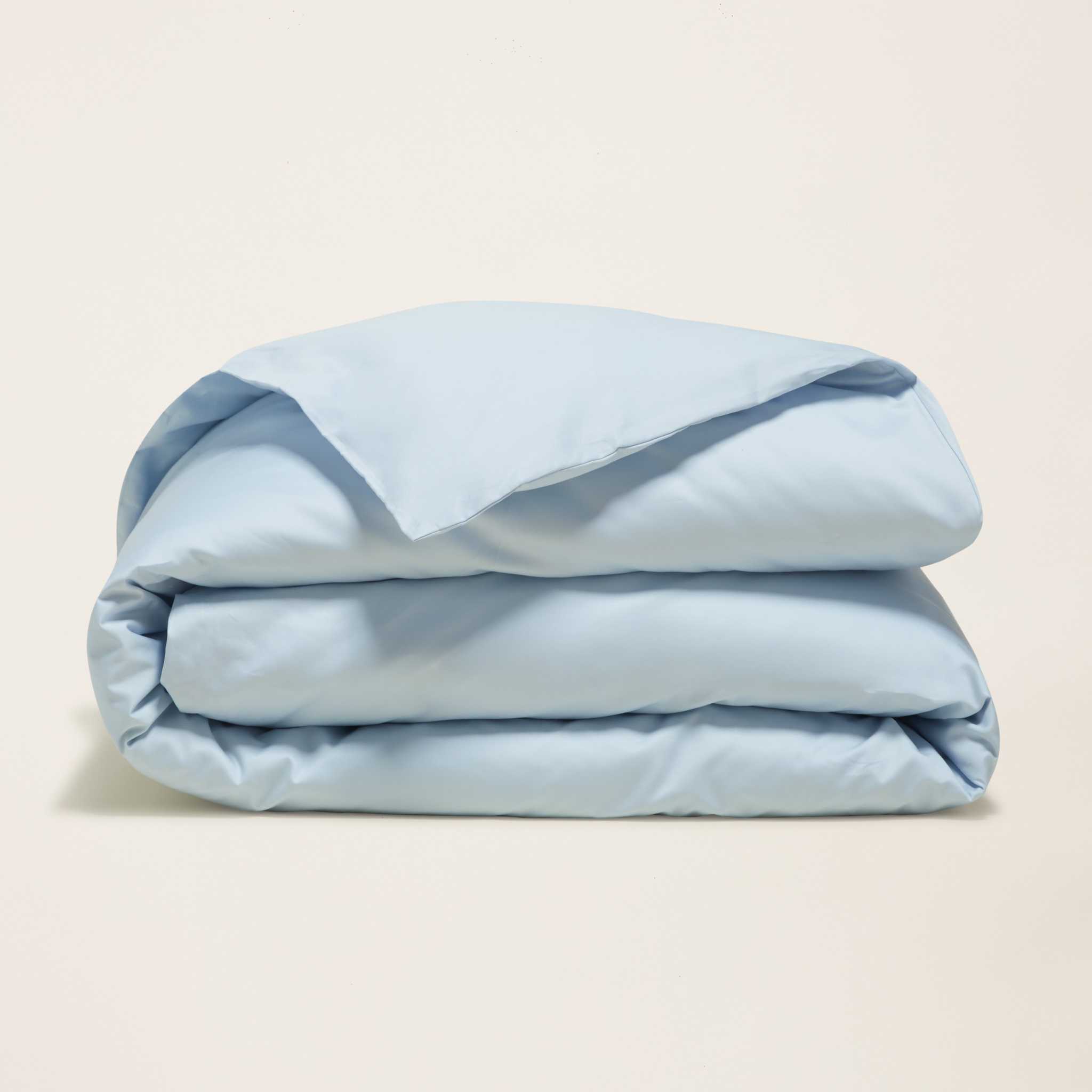 Luxe Australian Sateen duvet cover in pale blue cotton with a smooth finish, folded into soft layered folds