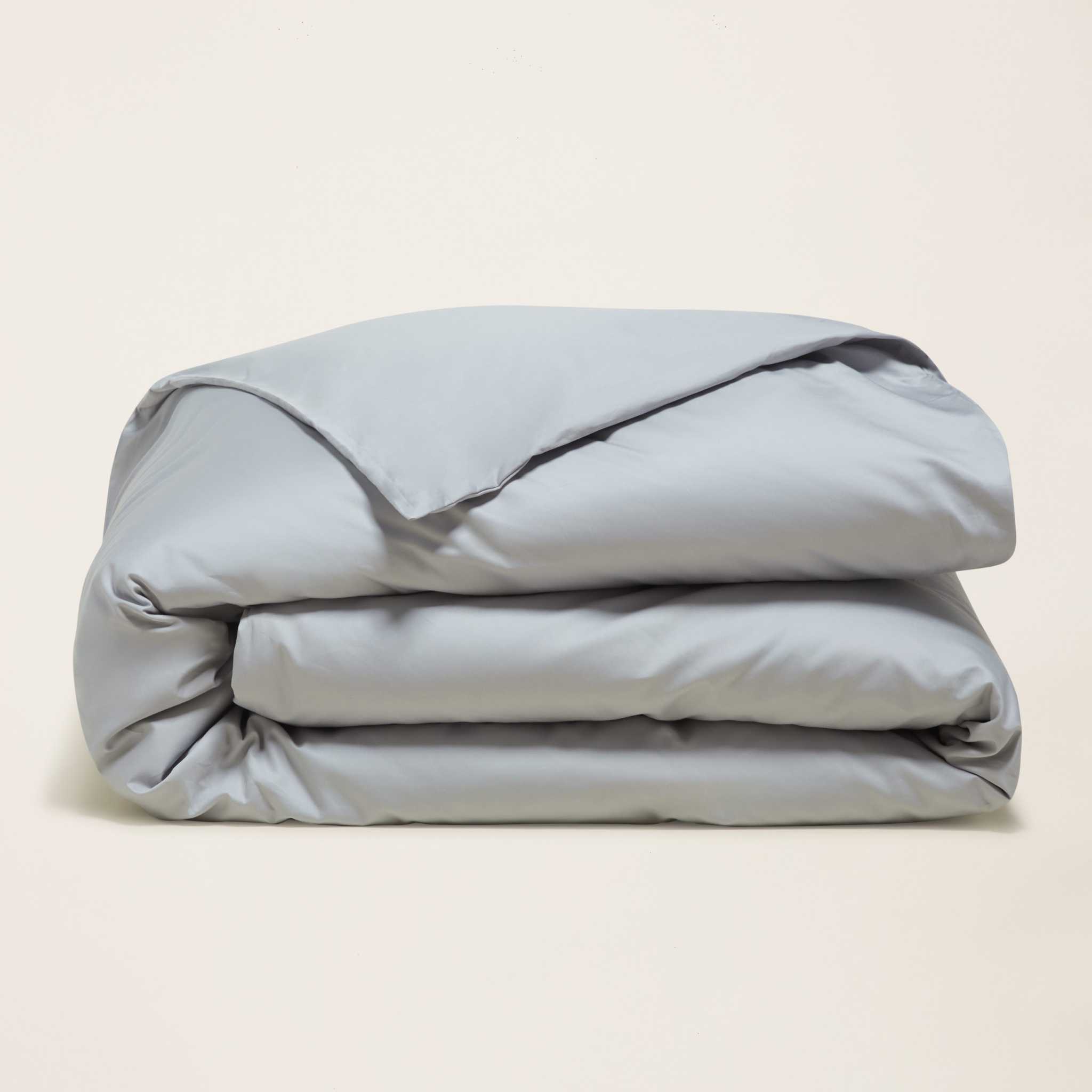 Luxe Australian Sateen duvet cover in solid pale gray cotton, folded with a smooth finish and subtle sheen