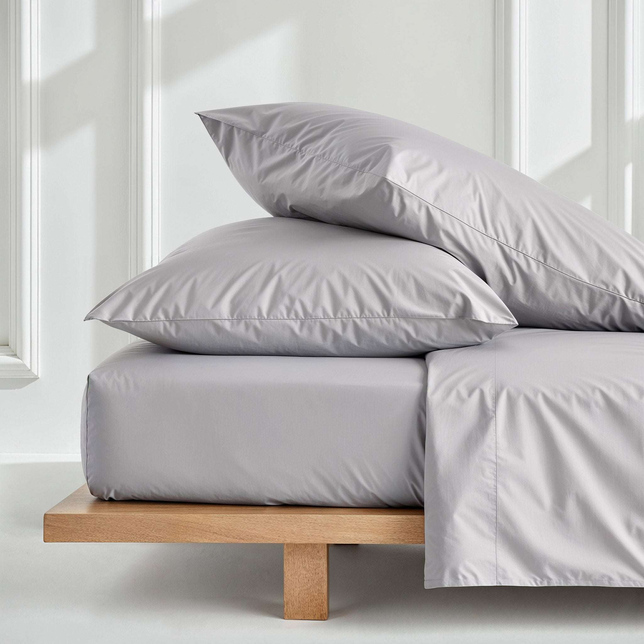 Luxe Australian Sateen Pillowcase Set in smooth light grey cotton, with two plump pillowcases and matching bedding