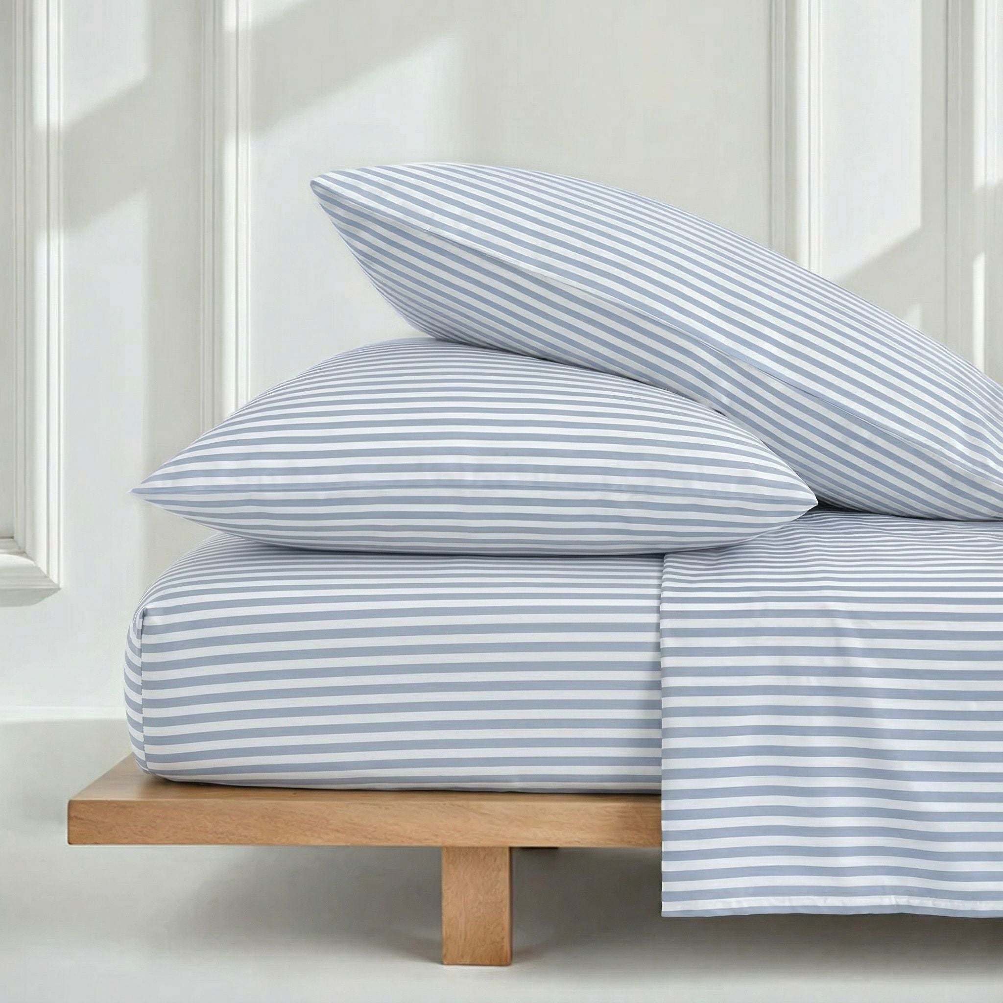 Luxe Australian Sateen Sheet Set in blue and white striped cotton, featuring matching pillowcases and neatly draped sheets