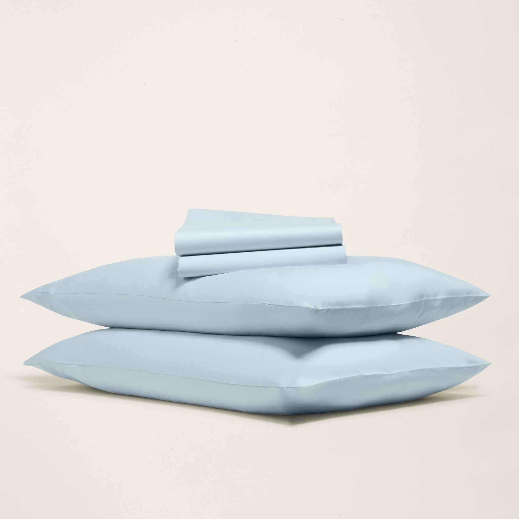 Luxe Australian Sateen Sheet Set in pale blue cotton, with two plump pillows and neatly folded sheets