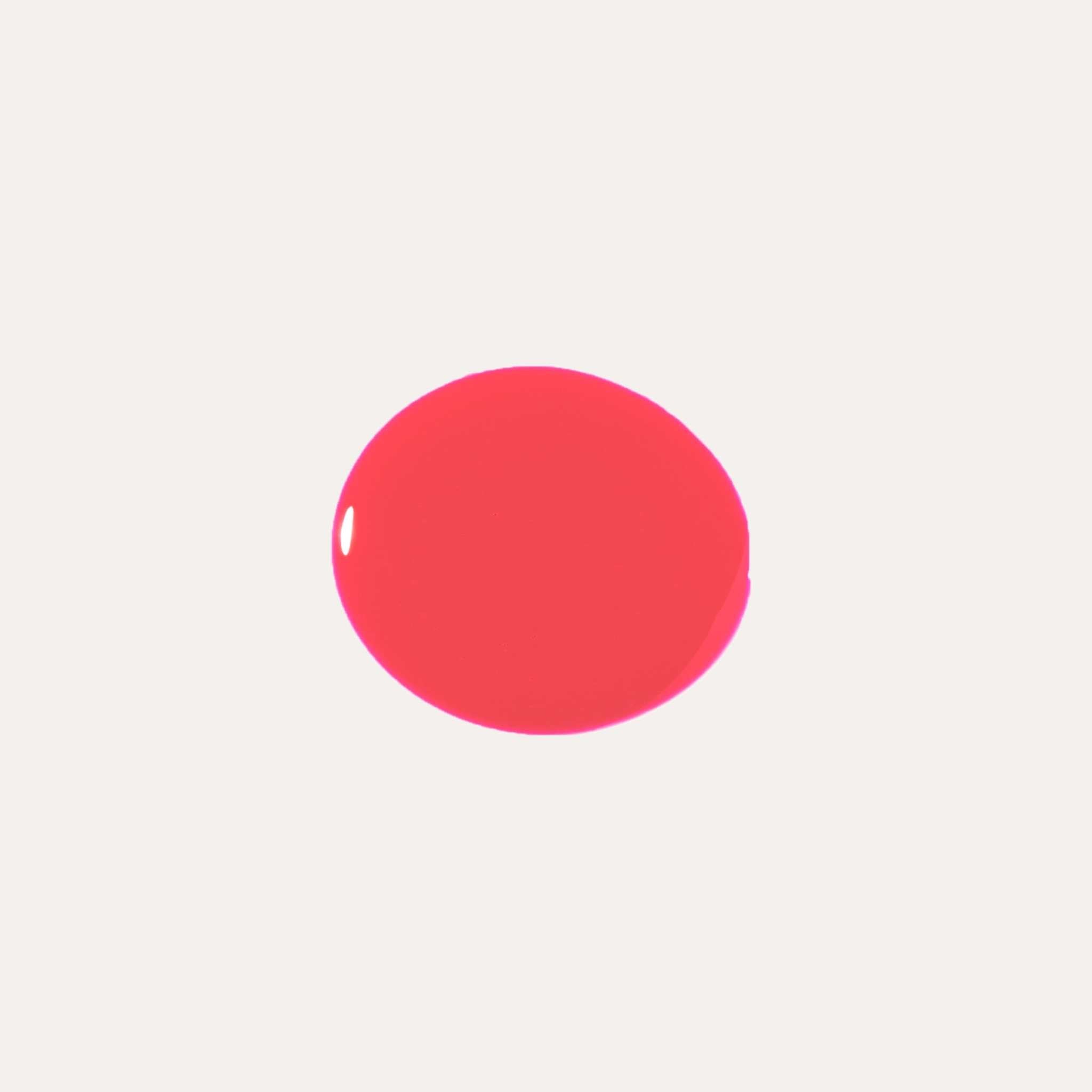 Luxe Lip Nourishing Oil swatch in vibrant coral pink with a smooth, glossy finish and rich, even color.