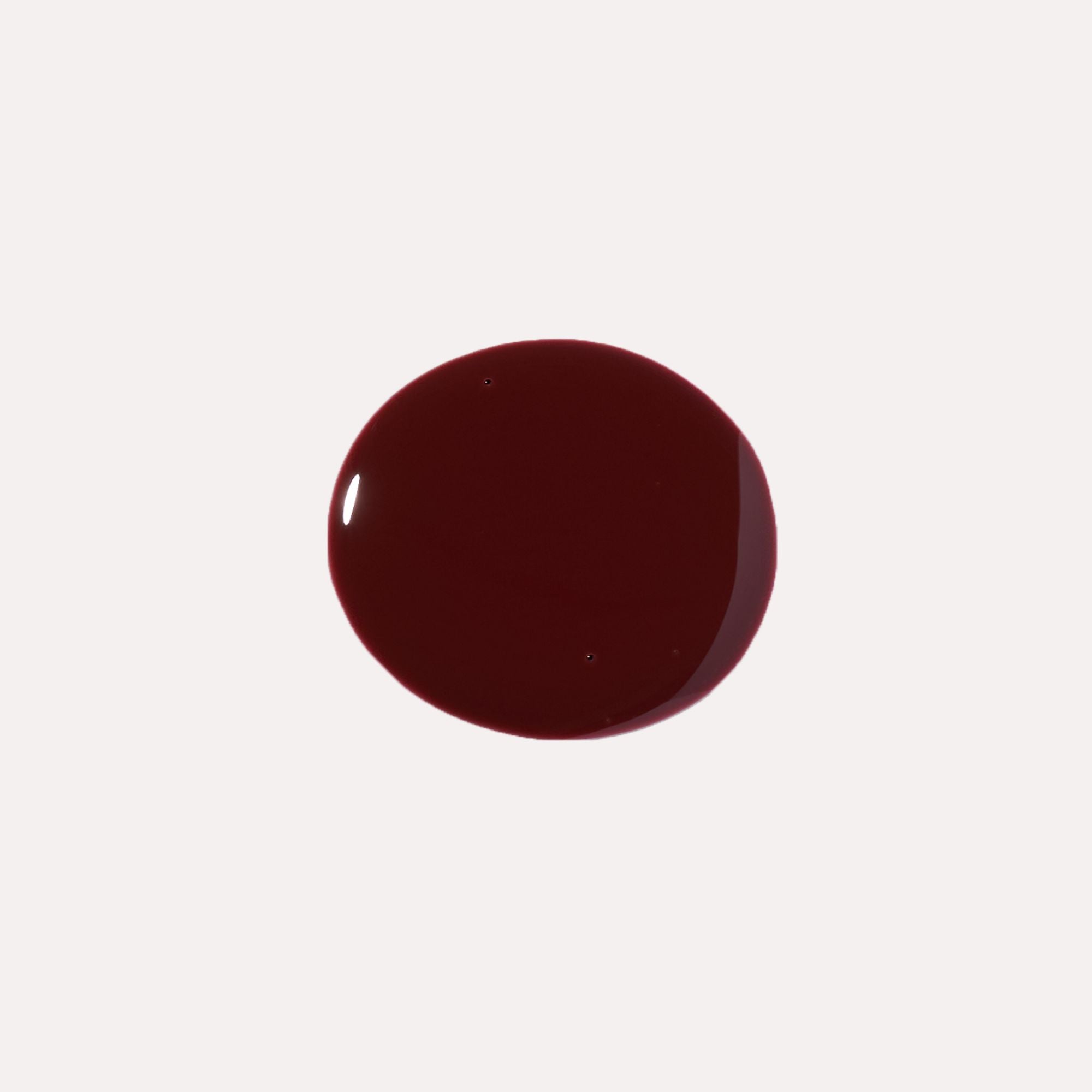 Luxe Lip Nourishing Oil in a deep burgundy shade, shown as a glossy, smooth swatch of tinted lip oil